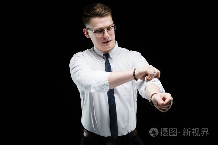 金发男人卷起白色衬衣袖子