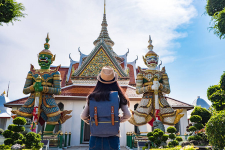 亚洲女性游客在休闲度假期间访问两个巨人。在阿伦寺庙曼谷的地标, 泰国