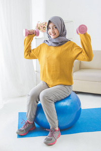 有魅力的穆斯林女人健身用哑铃