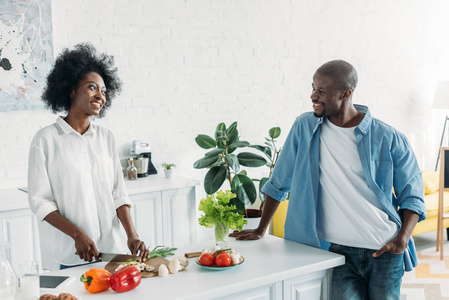 非洲裔美国人的男人看着妻子在厨房做饭早餐在家里