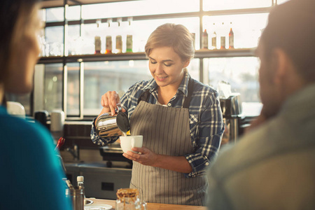 有经验的微笑咖啡师为顾客做咖啡