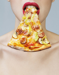 年轻饿女人吃一块比萨饼，白色衬底上分离。完美的肌肤和自然构成了