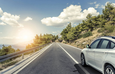 阳光下行驶在高速公路上超速行驶的白公共汽车运动模糊在蜿蜒的道路上