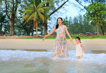 日落时分, 母亲和女儿在海滩上放松