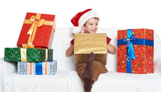 礼品盒圣诞假日概念与红色圣诞老人的帮手帽子的男孩