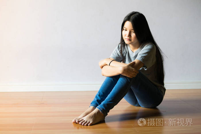 伤心女人独自坐在一个空房间