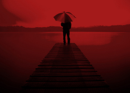 男人在湖的抱着一把伞