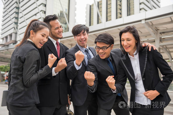 商业团队用举起的武器庆祝成功