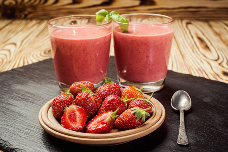 健康草莓酸奶与新鲜浆果在老木背景