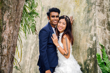 订婚照片订婚的异族情侣 (印度人和中国妇女) 在公园里摆出婚纱照片.