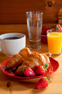 美味的早餐与牛角面包和草莓