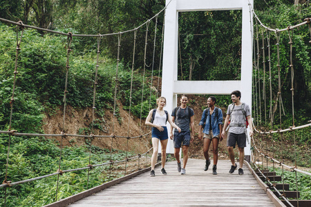 一群朋友在热带乡村的桥上漫步冒险和旅程概念