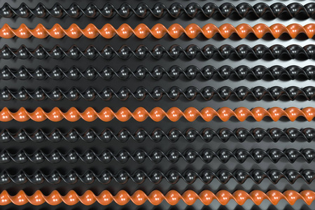 在黑色背景上的黑色和橙色的塑料螺旋棒照片