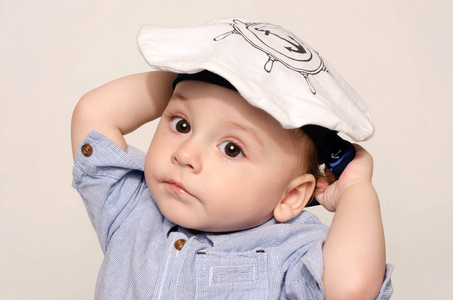 一个可爱的小宝贝男孩看着相机，戴着一顶水手帽子的肖像