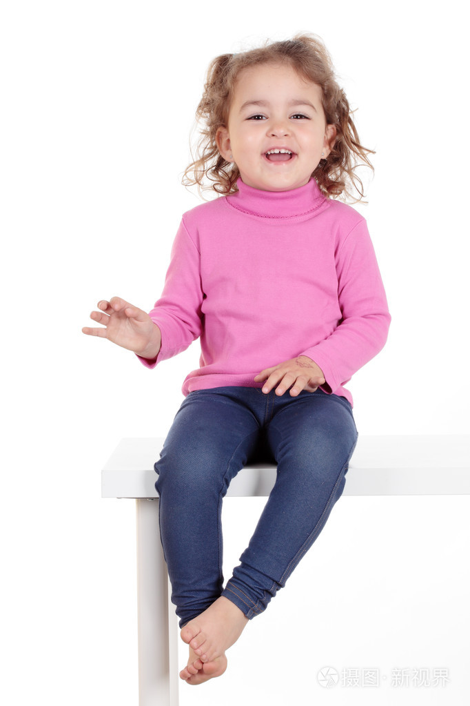 美丽的小女孩微笑着坐在一张桌子