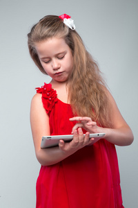 女孩穿着红色举行数字平板电脑
