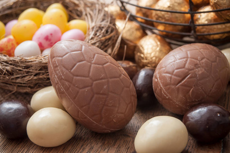 各种巧克力复活节彩蛋在木质背景下