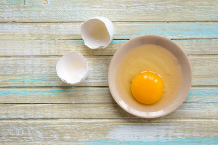 鸡蛋上的木质背景, 原始的蛋黄在一个板块的顶部视图