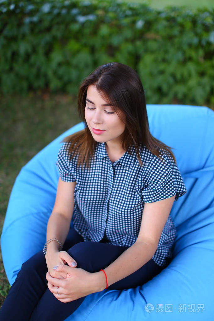 坐在椅子上摆姿势的漂亮女性肖像为摄影