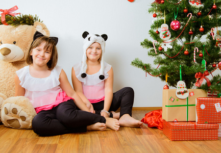 两个性格开朗的女孩有一个有趣的附近的圣诞树