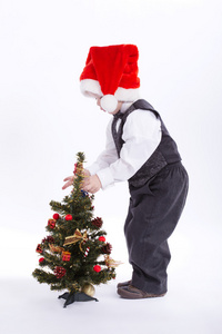 圣诞老人的帽子的男孩装饰圣诞树