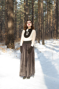 在冬季的森林里的长裙子的女孩