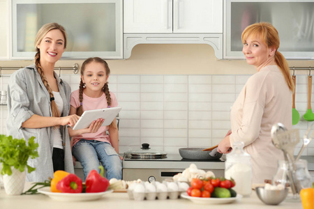 她的女儿和母亲在厨房的年轻妇女