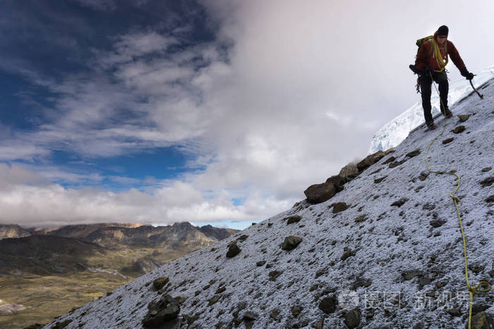 在秘鲁安第斯山脉的山脉海岸攀登高峰后雄性登山者下降了陡峭的卵石和