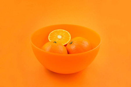 橙色的背景橙色.多汁的橘子片.碗与桔子摄影图