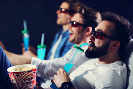 一群快乐的朋友坐在电影院看电影和吃爆米花