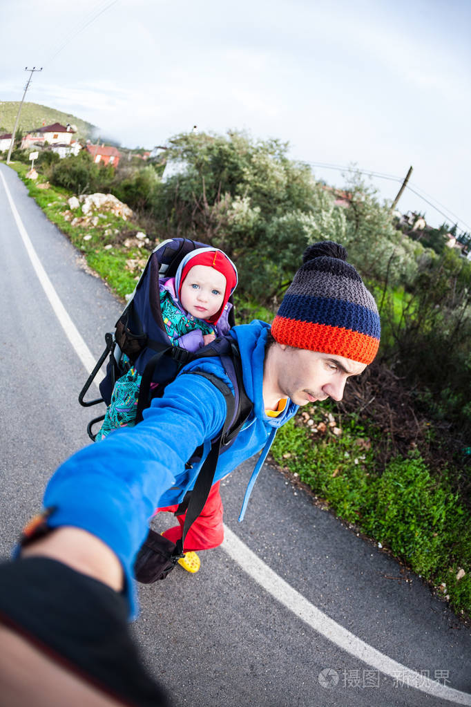 一个男人背着一个孩子在背包里