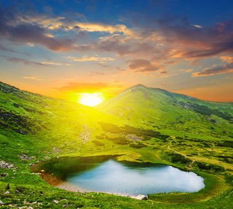 与小湖在日落时的绿色山谷