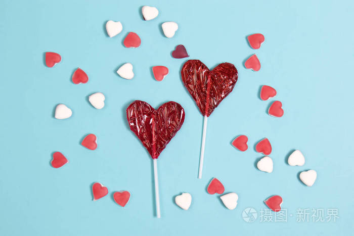 深蓝色背景下心脏形状的红色棒糖糖