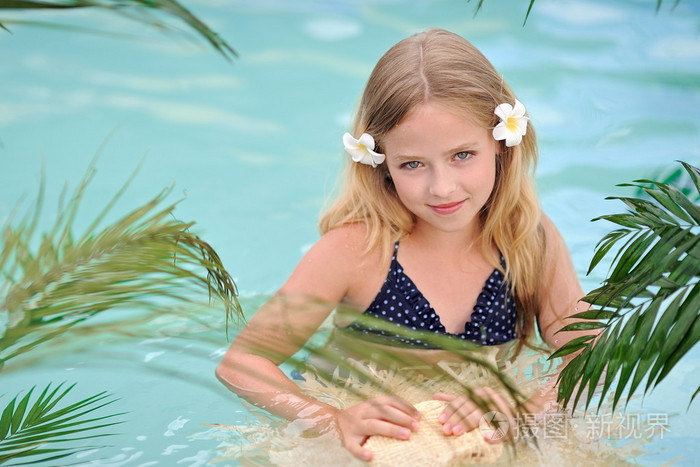 在泳池里的热带风格的小女孩的肖像