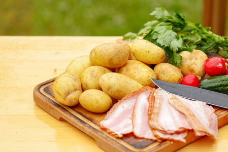 新鲜生土豆肉和蔬菜和刀子在木桌上