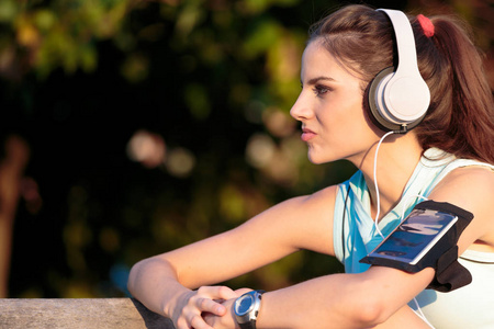 女人从她的智能手机听音乐用耳机