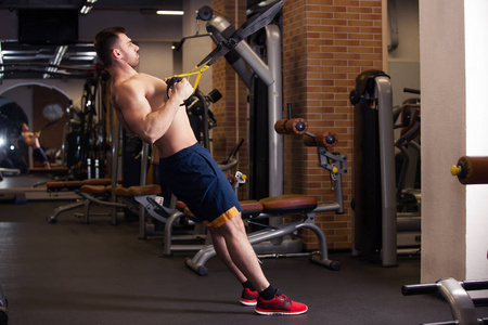 有吸引力的人做 Crossfit 在健身房工作室推 Ups 健身带