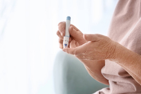 老年妇女糖尿病患者在家测量血糖水平, 特写照片