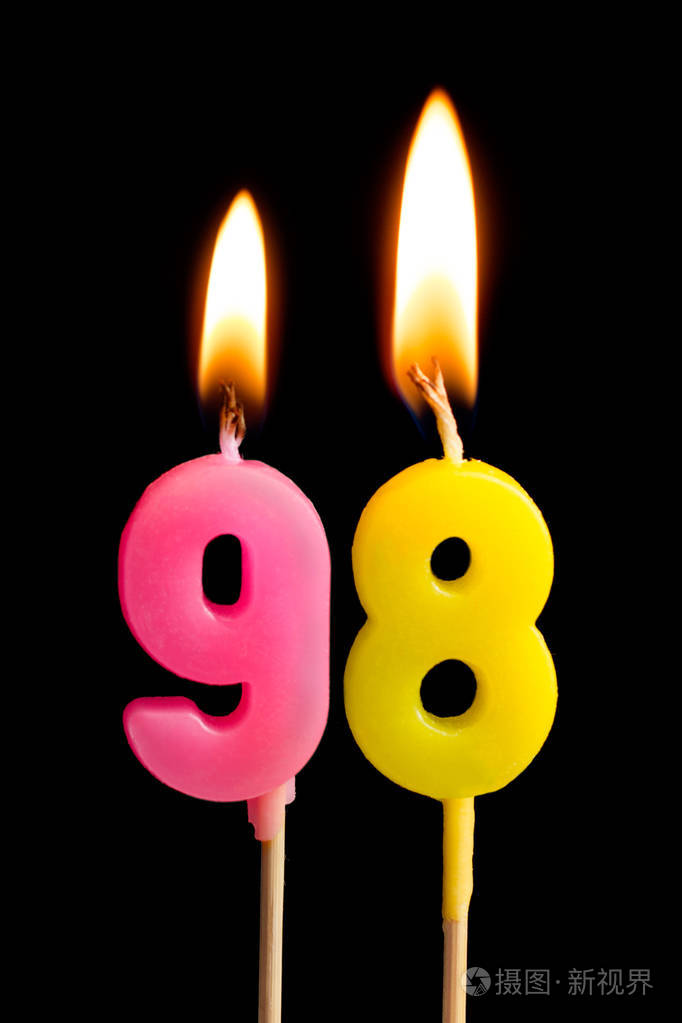 燃烧蜡烛的形式为98九十八数字日期的蛋糕孤立的黑色背景庆祝生日周年