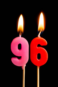 燃烧蜡烛的形式为96九十六 (数字, 日期) 的蛋糕孤立的黑色背景.