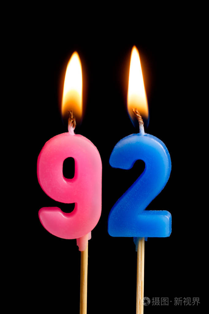 燃烧蜡烛的形式为92九十二数字日期的蛋糕孤立的黑色背景庆祝生日周年