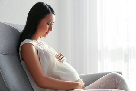 怀孕的女人坐在扶手椅上