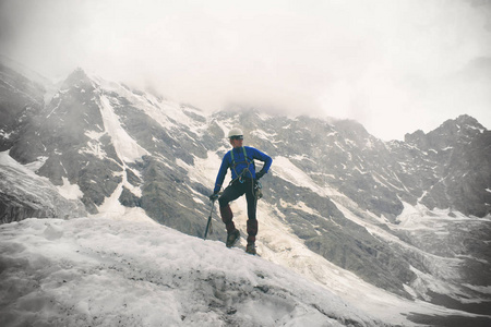 带着冰斧的登山运动员站在冰川的顶端。