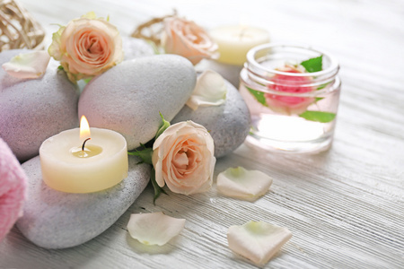 组成的鲜花 蜡烛和白色的木制背景，在 spa 沙龙上的石头