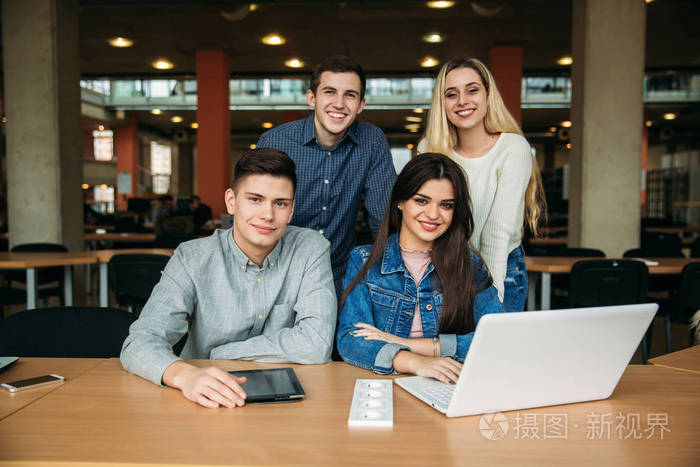 一群在学校图书馆学习的大学生, 一个女孩和一个男孩正在使用一台