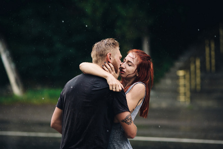 美丽的夫妇在雨中亲吻