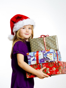 可爱的小学龄前女孩戴着红色圣诞老人帽和礼品盒