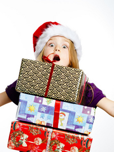 可爱的小学龄前女孩戴着红色圣诞老人帽和礼品盒