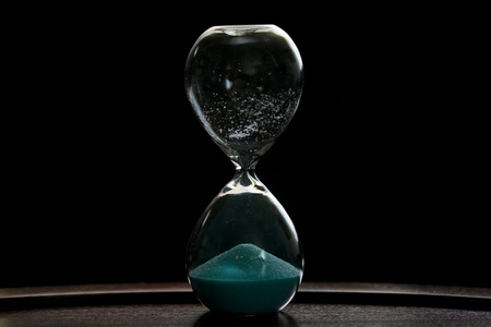 倒计时三分钟在黑色背景上的沙漏照片