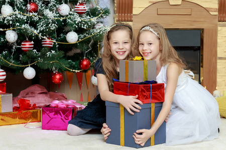 女孩双胞胎与礼品 e 圣诞树